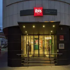 Wejście do Ibis Hotel Paris Gare de Lyon Diderot nocą. Widać podświetlany znak hotelu, szklane drzwi i schody.