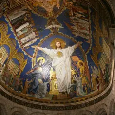 Witraż w bazylice Sacré-Cœur przedstawia Chrystusa z rozłożonymi ramionami, otoczonego przez świętych i aniołów.
