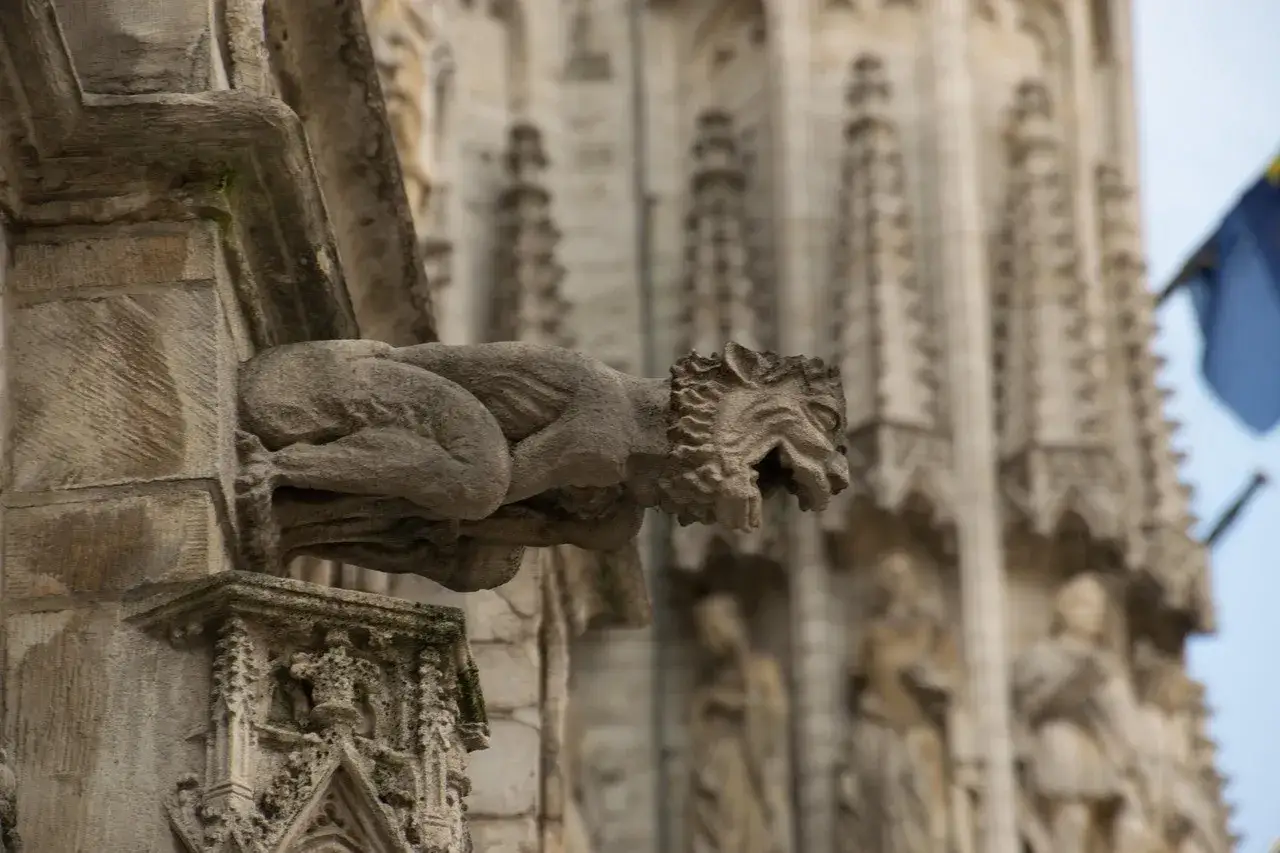 Kamienny gargulec Notre Dame, z otwartą paszczą, spogląda z wysokości.