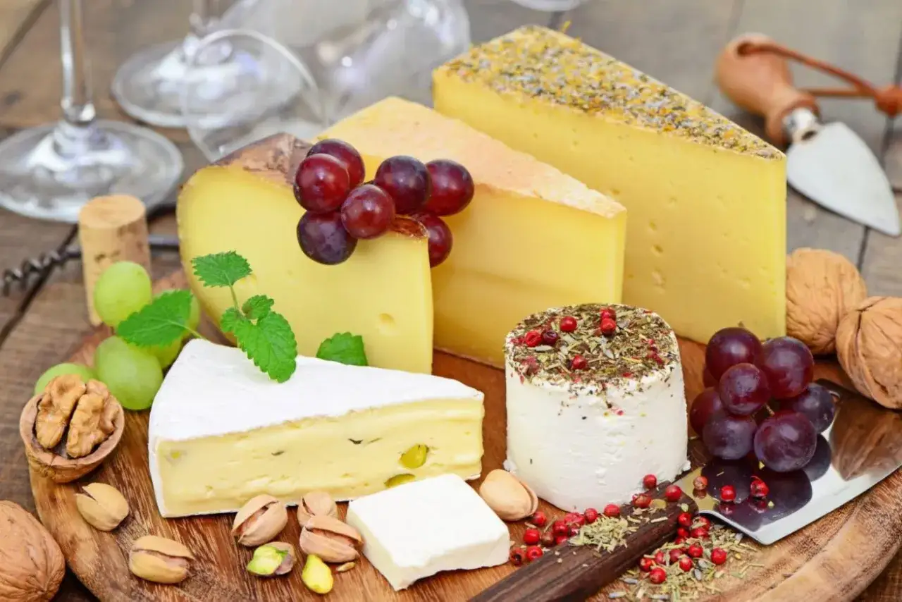 Deska serów z winogronami, orzechami i pistacjami. To właśnie co jedzą francuzi, delektując się wykwintnymi smakami.