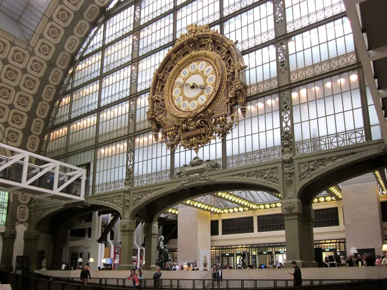 Złoty zegar w muzeum d'Orsay, zawieszony pod szklanym dachem, wskazuje czas zwiedzającym.