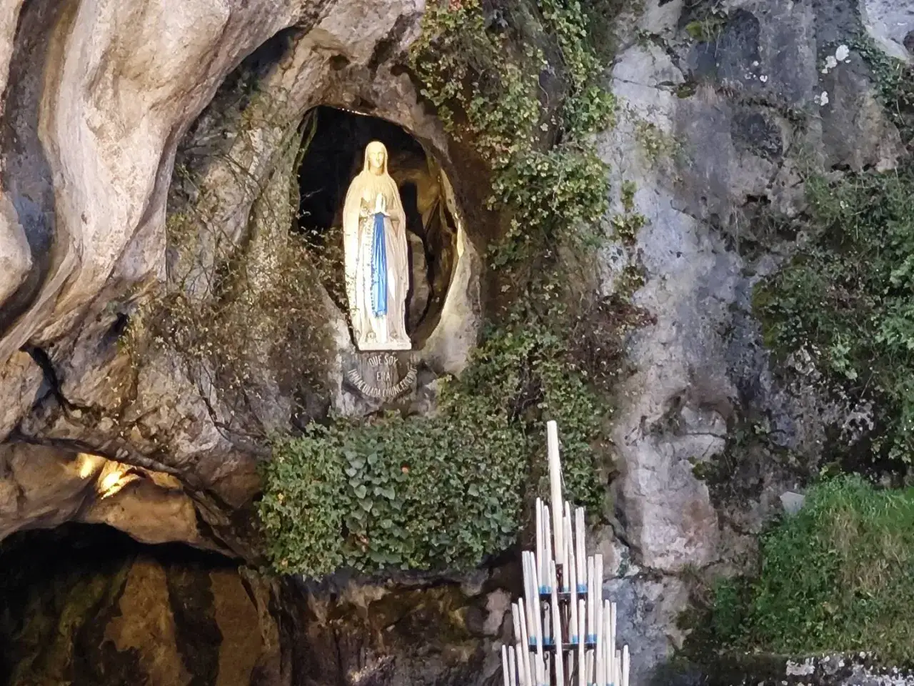 Figurka Matki Boskiej w grocie, serce francuskiego ośrodka kultu maryjnego. Obok palące się świece.