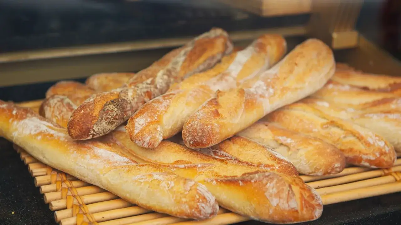 Świeże bagietki, charakterystyczne potrawy kuchni francuskiej, ułożone na bambusowej macie.